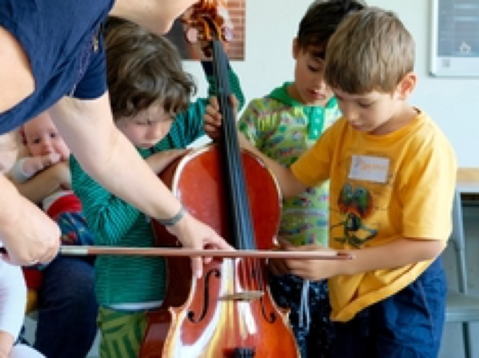 Kinder probieren Cello und Bogen aus